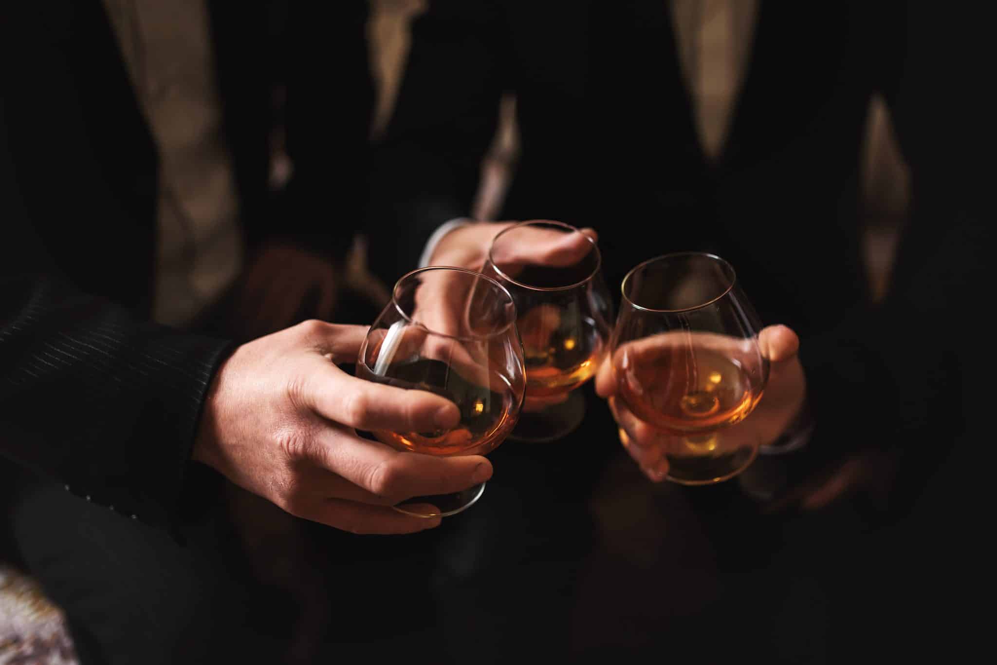 men with a friend. hold in the hands of glasses of whiskey. close up
